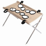 Khaki mesh pet grooming hammock stand with black-edged openings, black straps, silver folding frame, and white foot caps on a white background.
