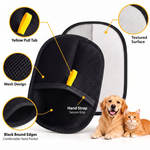 Pet hair removal glove detail image showing the yellow pull tab, black mesh surface, bound edges, hand pocket, and light gray textured reverse side.
