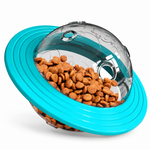 Interactive pet treat dispensing toy with a bright turquoise blue outer ring, clear transparent dome, and brown kibble inside on a clean white background
