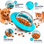 Pet treat dispensing toy with transparent dome, grooved ring, treat opening, and visible kibble, shown with a golden retriever and orange kitten on a white background.