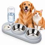 Golden retriever and orange-and-white tabby cat sitting behind a light gray pet feeder with two stainless steel bowls and a clear water reservoir.
