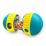 Yellow and teal interactive treat-dispensing dog toy with transparent center and side openings on a white background.