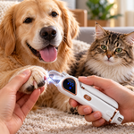A person uses a white and rose-gold pet nail grinder on a dog's paw while a cat watches nearby in a cozy indoor setting.
