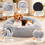 A dog rests on a grey round plush pet bed with callouts describing faux fur surface, donut shape, non-slip bottom, machine washable construction, and raised rim.
